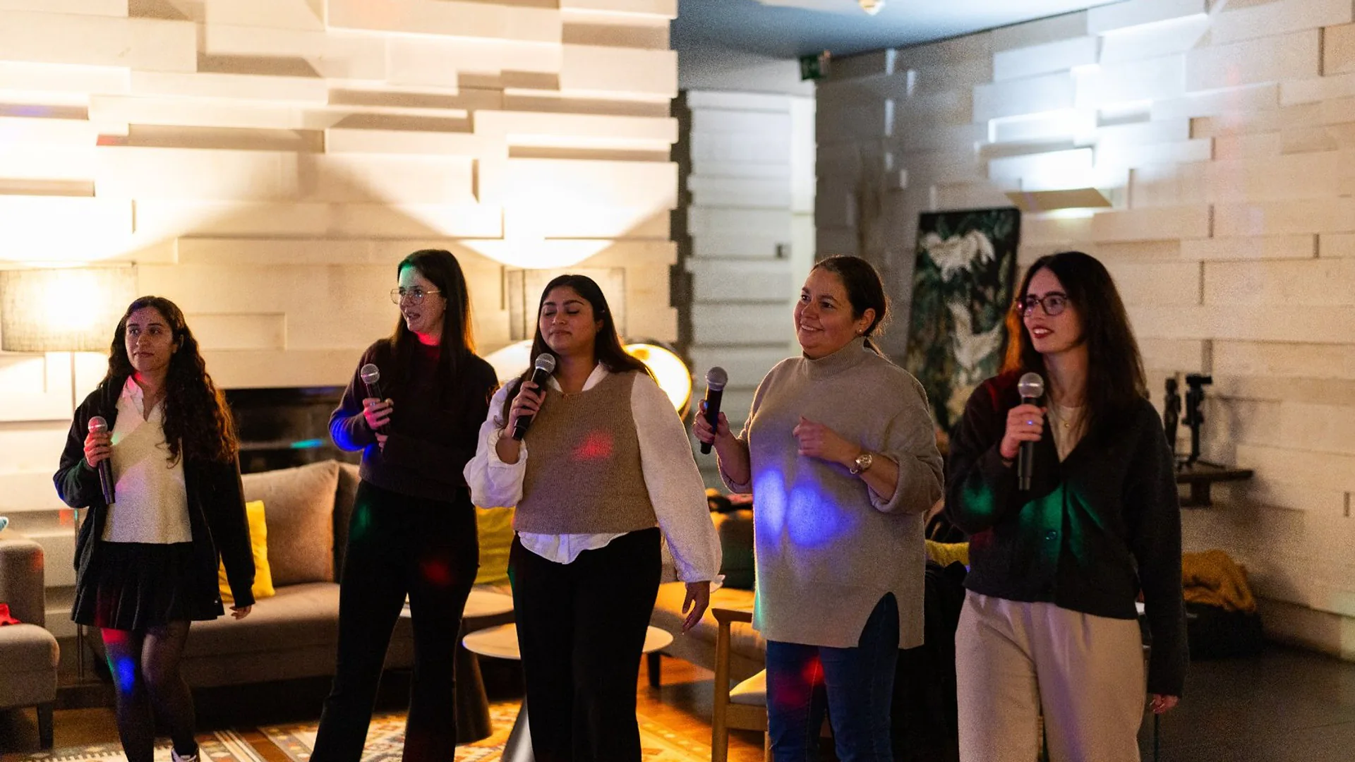 Woman presenting in front of a slide titled “What We Built in 2024,” adjusting her hair while standing beside the screen.