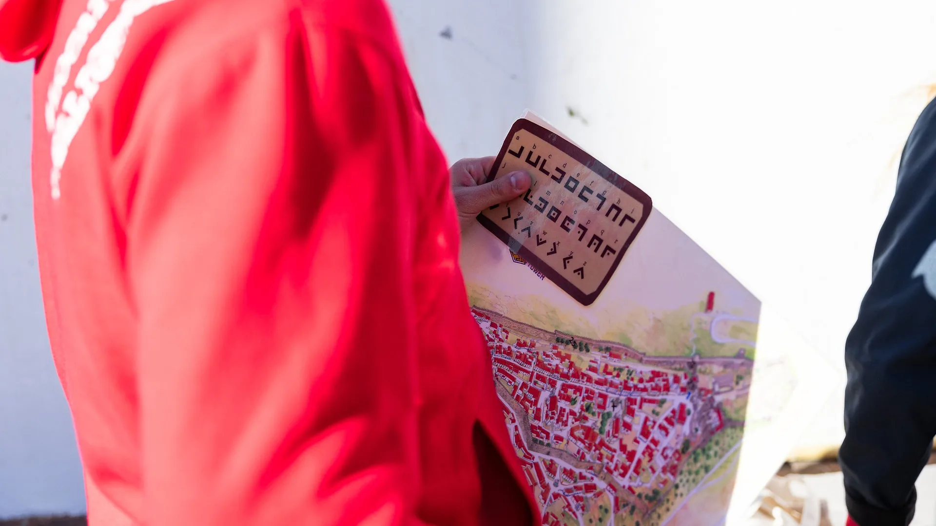 Four women sitting on a sofa looking at a phone together, smiling and preparing for karaoke in a softly lit lounge area.