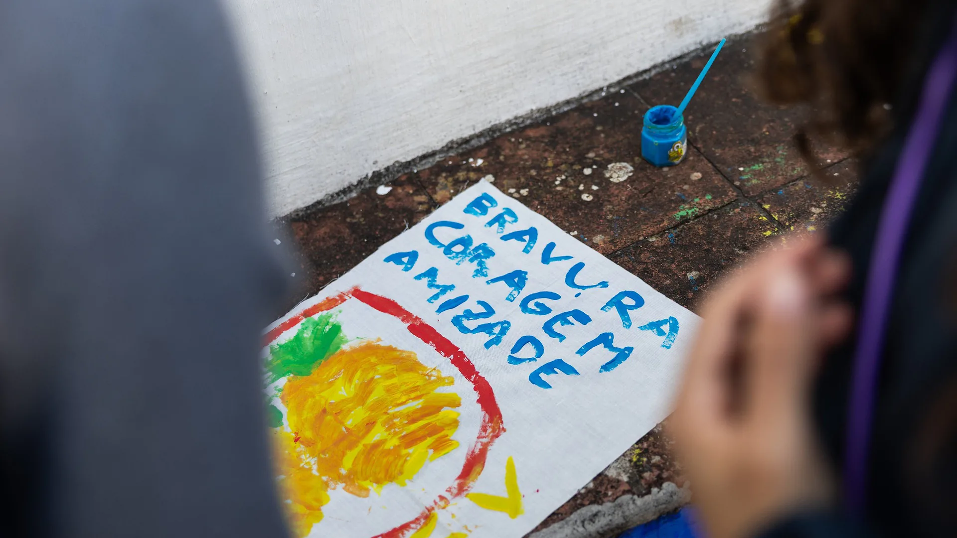 Four women sitting on a sofa looking at a phone together, smiling and preparing for karaoke in a softly lit lounge area.
