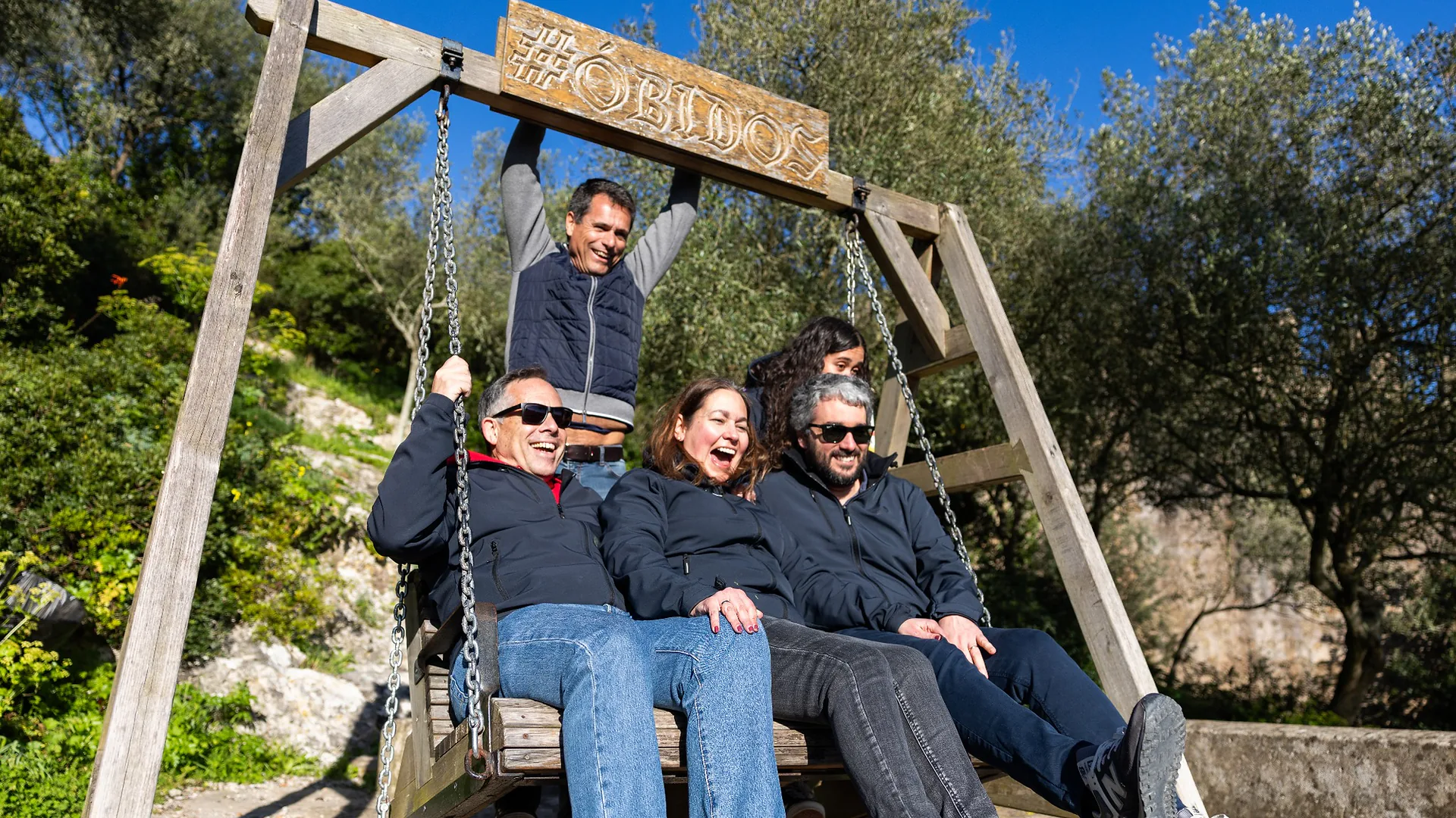 Group of women singing into microphones during karaoke, standing in front of a wall with warm ambient lighting.